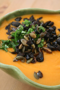 Velouté corail, olives noires et graines de courge toastées